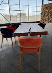Ragusa live-edge oak dining table with metal legs and velvet chairs in industrial studio