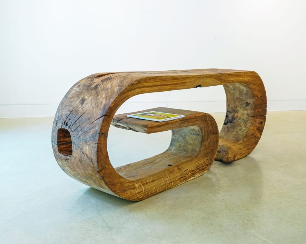 OZE sculptural wooden commode with floating shelf holding a tablet in a minimalist gallery